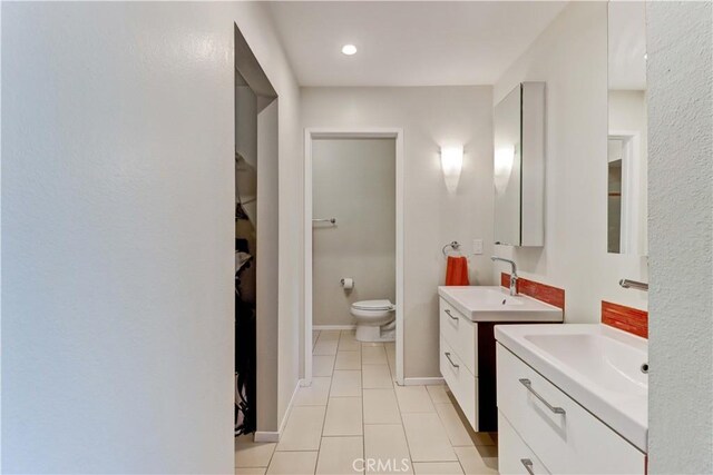 2032 E Bermuda St Unit 103, Long Beach, CA 90814 - bathroom with tile patterned flooring, two vanities, toilet, and a walk in closet