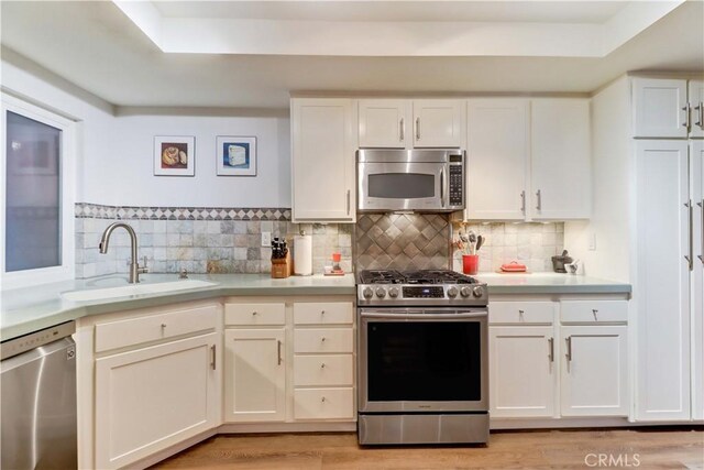 2032 E Bermuda St Unit 103, Long Beach, CA 90814 - kitchen with stainless steel appliances, a sink, light countertops, and white cabinetry