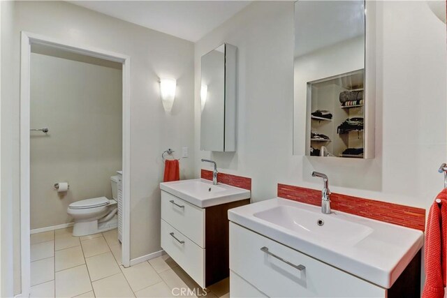 2032 E Bermuda St Unit 103, Long Beach, CA 90814 - full bathroom featuring two vanities, toilet, tile patterned flooring, and baseboards