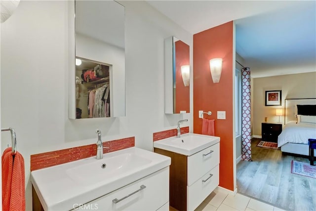 2032 E Bermuda St Unit 103, Long Beach, CA 90814 - ensuite bathroom with two vanities, baseboards, and a spacious closet