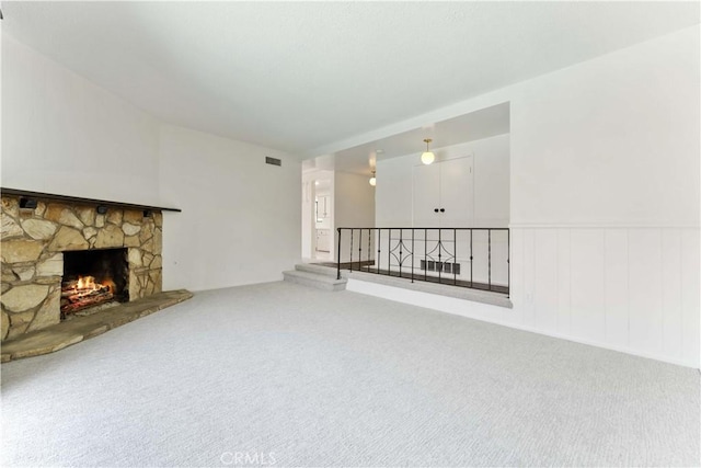 1315 E Wingate St, Covina, CA 91724 - unfurnished living room featuring carpet flooring, a stone fireplace, and wainscoting