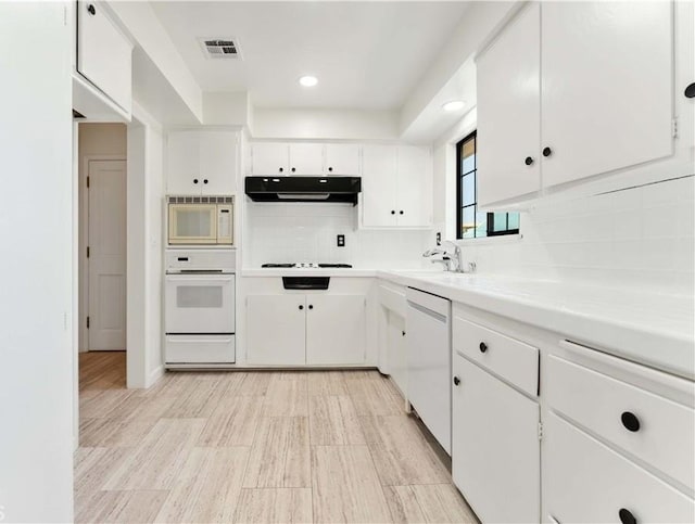 1315 E Wingate St, Covina, CA 91724 - kitchen featuring white appliances, under cabinet range hood, decorative backsplash, white cabinetry, and recessed lighting