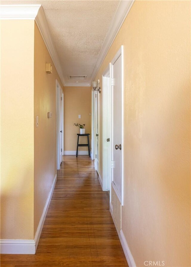 3158 Erie Ave, Merced, CA 95340 - hallway featuring a textured ceiling, wood finished floors, crown molding, and baseboards