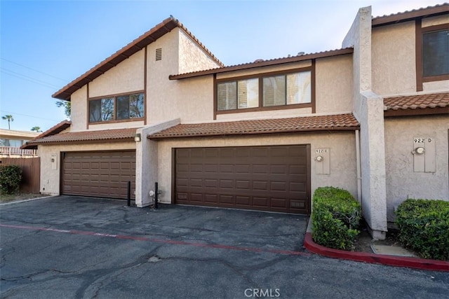 922 N Redding Way Unit E, Upland, CA 91786 - townhome / multi-family property featuring a garage, stucco siding, a tiled roof, and asphalt driveway