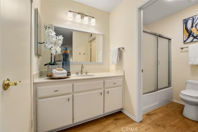 922 N Redding Way Unit E, Upland, CA 91786 - full bathroom with toilet, wood finished floors, vanity, shower / bath combination with glass door, and baseboards