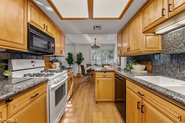 922 N Redding Way Unit E, Upland, CA 91786 - kitchen with black appliances, backsplash, light wood finished floors, and a chandelier
