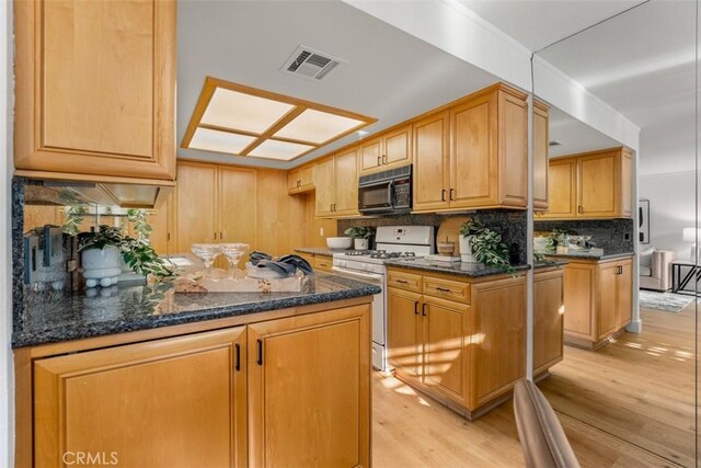 922 N Redding Way Unit E, Upland, CA 91786 - kitchen featuring black microwave, white gas range oven, tasteful backsplash, a peninsula, and light wood finished floors