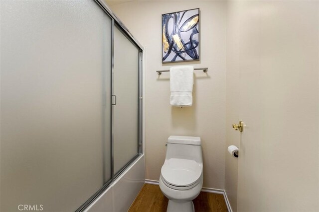 922 N Redding Way Unit E, Upland, CA 91786 - full bath with wood finished floors, toilet, baseboards, and combined bath / shower with glass door