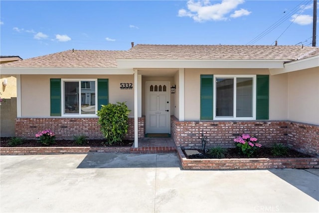5332 Huntley Ave, Garden Grove, CA 92845 - view of exterior entry with brick siding, stucco siding, and a shingled roof