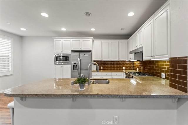 76 City Stroll, Irvine, CA 92620 - kitchen with appliances with stainless steel finishes, a sink, a peninsula, white cabinetry, and recessed lighting