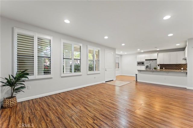76 City Stroll, Irvine, CA 92620 - unfurnished living room featuring light wood-style flooring, recessed lighting, and baseboards