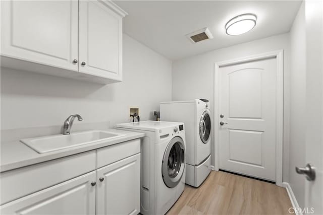 76 City Stroll, Irvine, CA 92620 - laundry room featuring cabinet space, washing machine and dryer, and light wood-style flooring