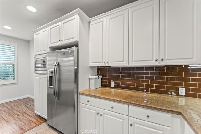 76 City Stroll, Irvine, CA 92620 - kitchen with stainless steel refrigerator with ice dispenser, white cabinets, light stone counters, backsplash, and recessed lighting