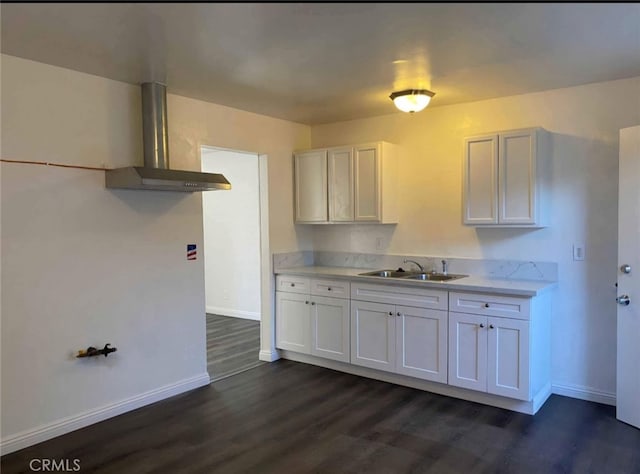 11215 Mulhall St, El Monte, CA 91731 - kitchen featuring a sink, wall chimney exhaust hood, dark wood-style flooring, baseboards, and white cabinets
