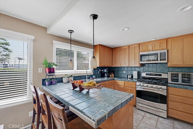 7038 De Celis Pl Unit 9, Van Nuys, CA 91406 - kitchen featuring stainless steel appliances, a peninsula, plenty of natural light, decorative backsplash, and recessed lighting