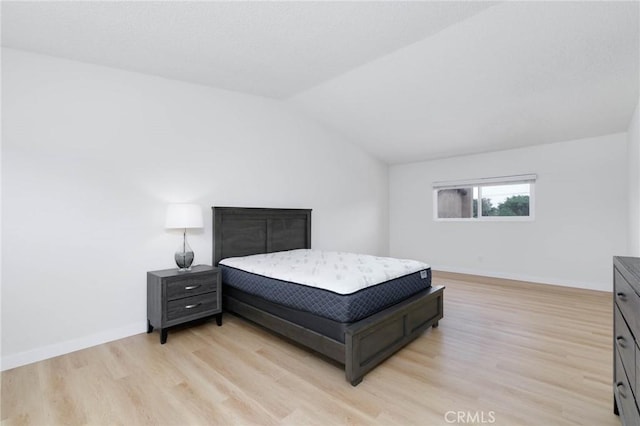 12105 Ramona Blvd, El Monte, CA 91732 - bedroom with light wood-style flooring, vaulted ceiling, and baseboards