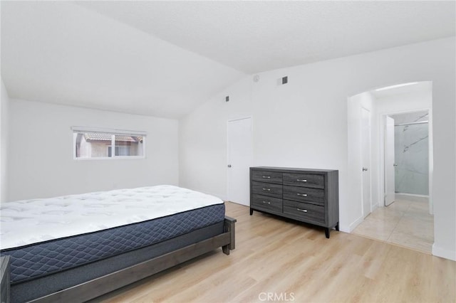 12105 Ramona Blvd, El Monte, CA 91732 - bedroom featuring light wood-style flooring, arched walkways, and lofted ceiling