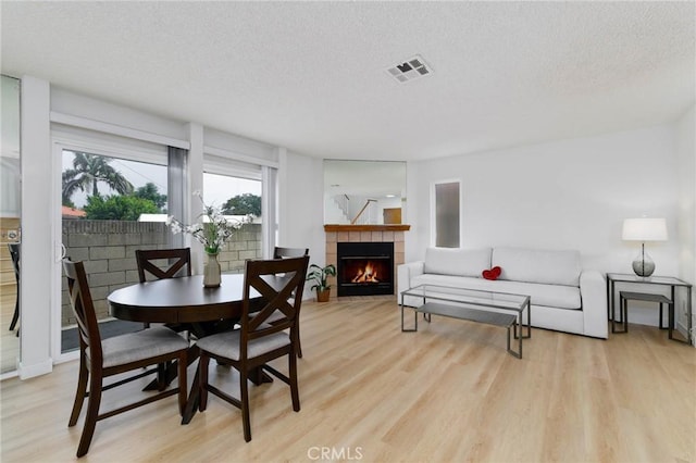 12105 Ramona Blvd, El Monte, CA 91732 - dining area with a textured ceiling, light wood-style flooring, and a fireplace