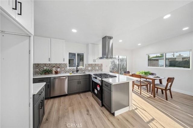 957 N Jasmine Ave, Ontario, CA 91762 - kitchen featuring stainless steel appliances, island range hood, a sink, a peninsula, and light wood finished floors