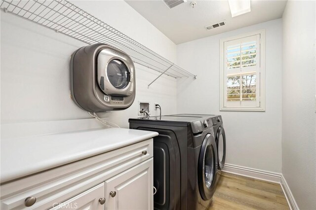 211 Groveland, Irvine, CA 92620 - laundry room featuring cabinet space, washing machine and clothes dryer, baseboards, and light wood-type flooring