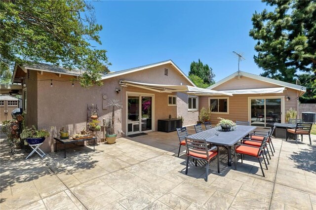 18770 Community St, Northridge, CA 91324 - rear view of house featuring a patio area, stucco siding, outdoor dining area, and cooling unit