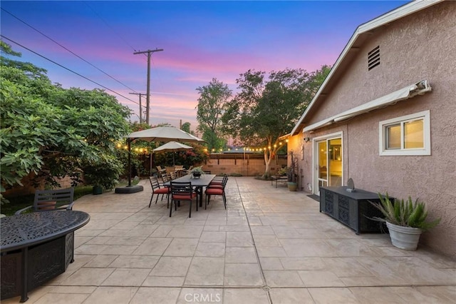 18770 Community St, Northridge, CA 91324 - patio terrace at dusk with outdoor dining area, a fenced backyard, and a patio area