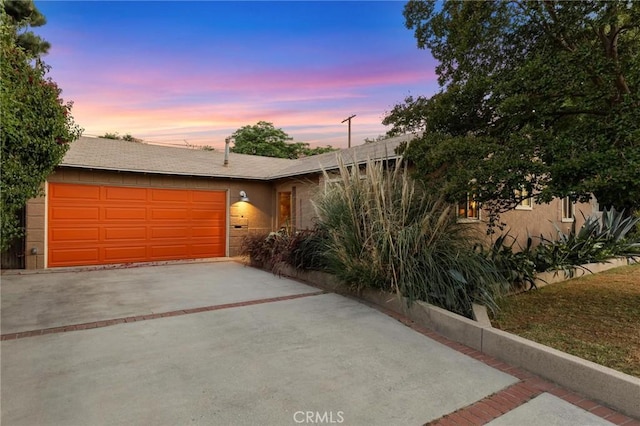 18770 Community St, Northridge, CA 91324 - view of front facade featuring concrete driveway, a garage, and stucco siding