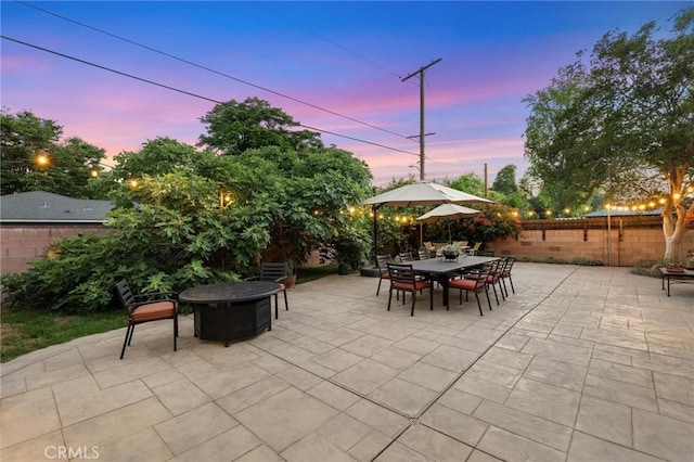 18770 Community St, Northridge, CA 91324 - patio terrace at dusk featuring a fire pit, a patio area, a fenced backyard, and outdoor dining area