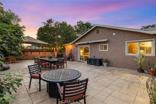 18770 Community St, Northridge, CA 91324 - patio terrace at dusk featuring a patio and outdoor dining space