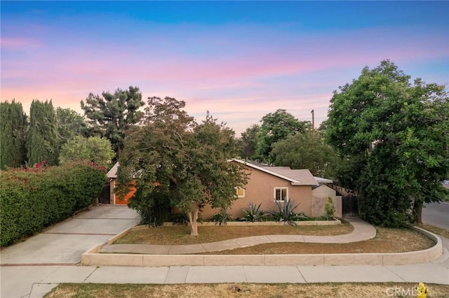 18770 Community St, Northridge, CA 91324 - property exterior at dusk with stucco siding and concrete driveway