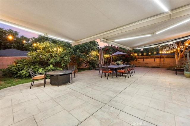 18770 Community St, Northridge, CA 91324 - patio terrace at dusk featuring a fire pit, a patio, a fenced backyard, and outdoor dining area