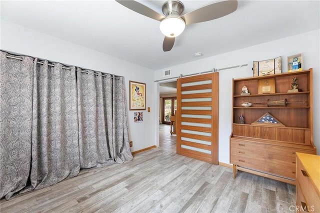 18770 Community St, Northridge, CA 91324 - spare room featuring a ceiling fan, a barn door, wood finished floors, and baseboards
