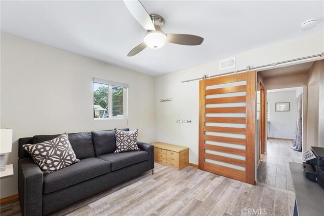 18770 Community St, Northridge, CA 91324 - living room featuring a barn door, light wood finished floors, and a ceiling fan