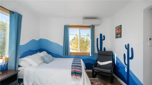 61748 Valley View Cir, Joshua Tree, CA 92252 - bedroom with an AC wall unit, wood finished floors, and baseboards