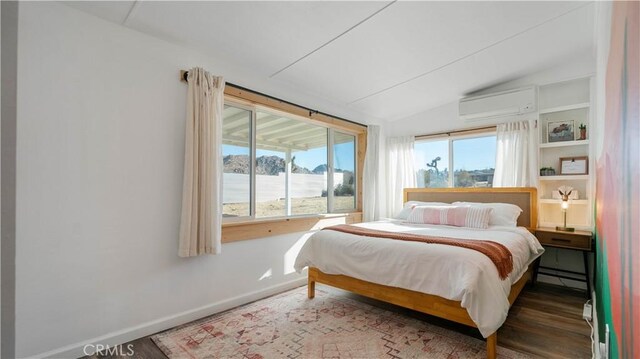 61748 Valley View Cir, Joshua Tree, CA 92252 - bedroom featuring a wall mounted AC, lofted ceiling, wood finished floors, baseboards, and a baseboard radiator