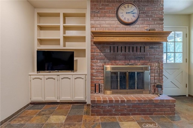 2020 Station Ave, Atwater, CA 95301 - unfurnished living room with built in features, stone tile flooring, a brick fireplace, and baseboards