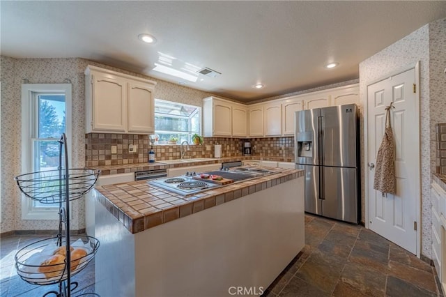 2020 Station Ave, Atwater, CA 95301 - kitchen with appliances with stainless steel finishes, tile countertops, a sink, white cabinets, and decorative backsplash