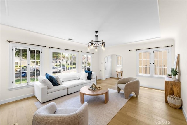827 Hauser Blvd, Los Angeles, CA 90036 - living area with arched walkways, a chandelier, light wood-type flooring, and baseboards