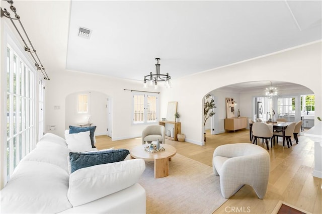 827 Hauser Blvd, Los Angeles, CA 90036 - living area featuring arched walkways, a chandelier, and light wood-style floors