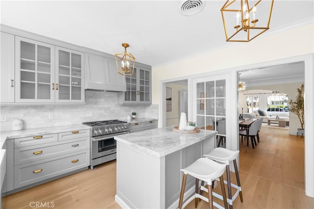 827 Hauser Blvd, Los Angeles, CA 90036 - kitchen featuring a chandelier, high end stainless steel range, gray cabinetry, tasteful backsplash, and crown molding