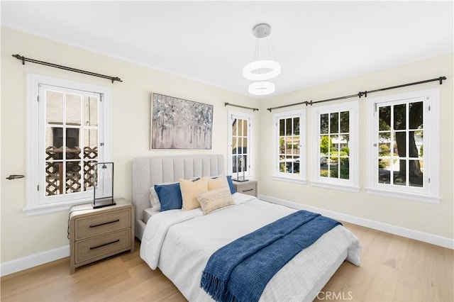 827 Hauser Blvd, Los Angeles, CA 90036 - bedroom featuring baseboards, light wood-type flooring, and multiple windows