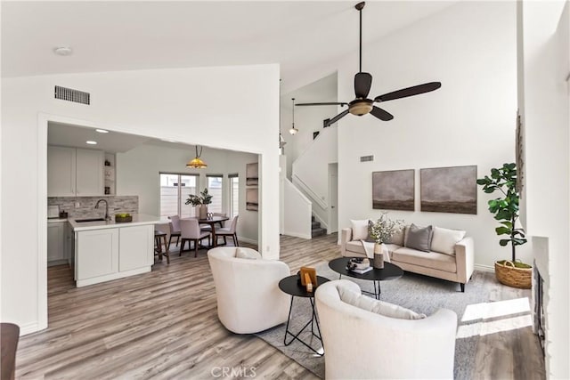 21592 Fernbrook Unit 195, Mission Viejo, CA 92692 - living area featuring vaulted ceiling, light wood-style flooring, stairway, baseboards, and ceiling fan