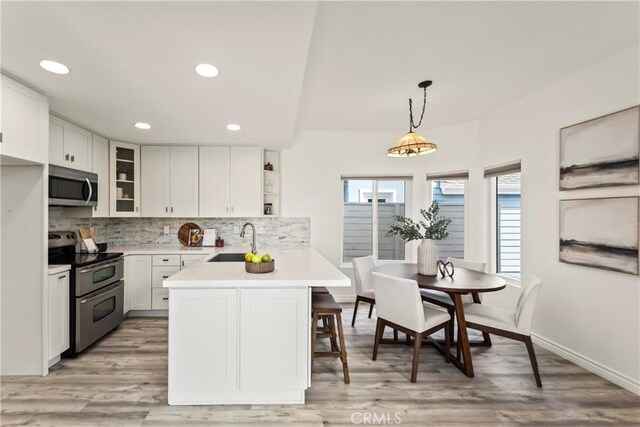 21592 Fernbrook Unit 195, Mission Viejo, CA 92692 - kitchen with stainless steel appliances, a peninsula, light countertops, a sink, and tasteful backsplash