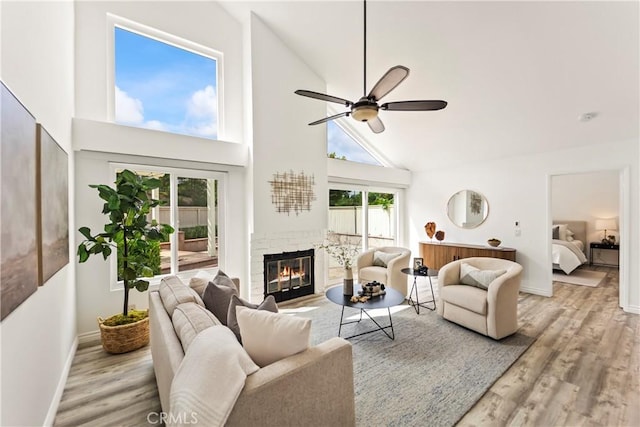21592 Fernbrook Unit 195, Mission Viejo, CA 92692 - living area with high vaulted ceiling, a ceiling fan, wood finished floors, a glass covered fireplace, and baseboards