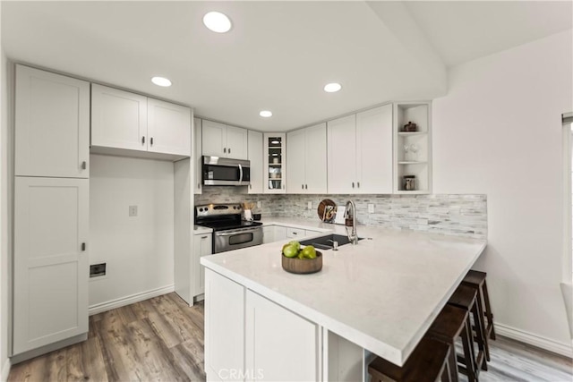 21592 Fernbrook Unit 195, Mission Viejo, CA 92692 - kitchen with stainless steel appliances, open shelves, a sink, a peninsula, and light countertops