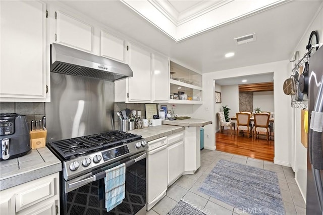 402 El Centro St Unit 13, South Pasadena, CA 91030 - kitchen with under cabinet range hood, tile countertops, stainless steel gas range oven, white cabinets, and decorative backsplash