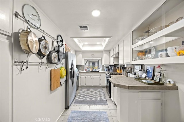 402 El Centro St Unit 13, South Pasadena, CA 91030 - kitchen featuring appliances with stainless steel finishes, tile countertops, white cabinets, open shelves, and light tile patterned floors
