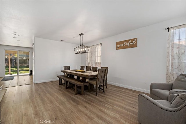 28867 Glencoe Ln, Menifee, CA 92584 - dining area with baseboards, light wood-type flooring, and a chandelier