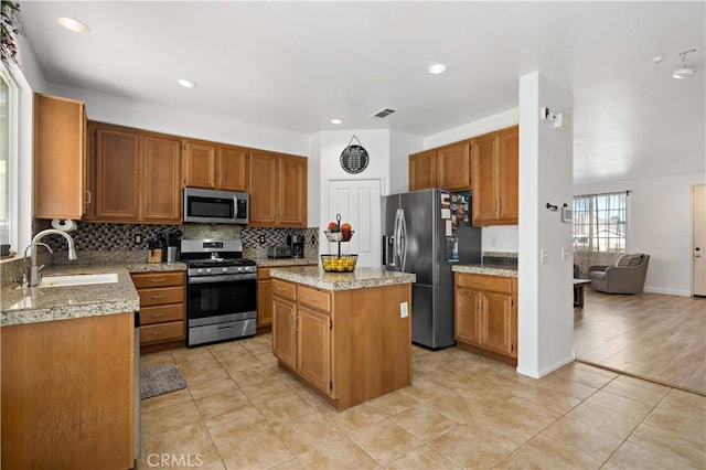28867 Glencoe Ln, Menifee, CA 92584 - kitchen featuring appliances with stainless steel finishes, a sink, backsplash, a center island, and light tile patterned flooring