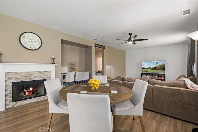 28867 Glencoe Ln, Menifee, CA 92584 - dining area featuring a ceiling fan, wood finished floors, and a stone fireplace